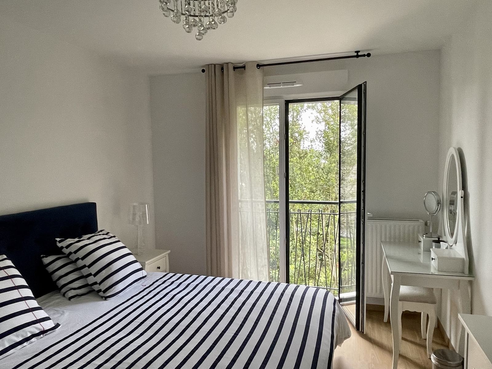 Chambre principale avec lit king size et porte-fenêtre sur le jardin